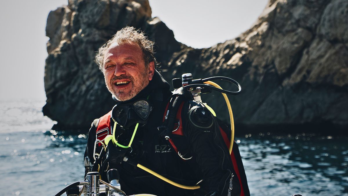 Peaceful contemplative diver with regulator breathing in zen-like meditation pose underwater in Costa Rica showing wisdom and life lessons learned through diving