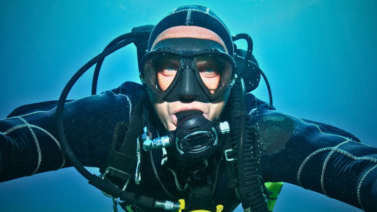 Technical diver assembling advanced multi-tank configuration and complex equipment on dive boat in Costa Rica showing technical diving preparation and gear setup
