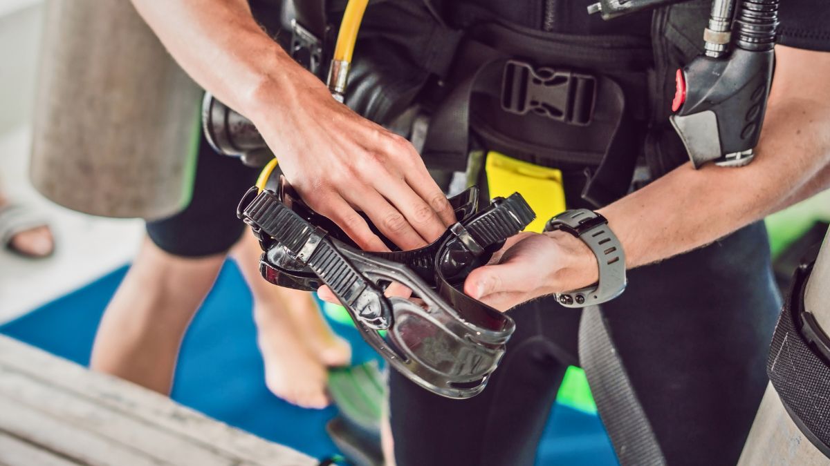 Why Does My Dive Mask Leak? 4 Common Reasons and How to Fix Them » Costa Rica Divers Diver checking dive mask seal around hood opening by running finger between mask skirt and neoprene