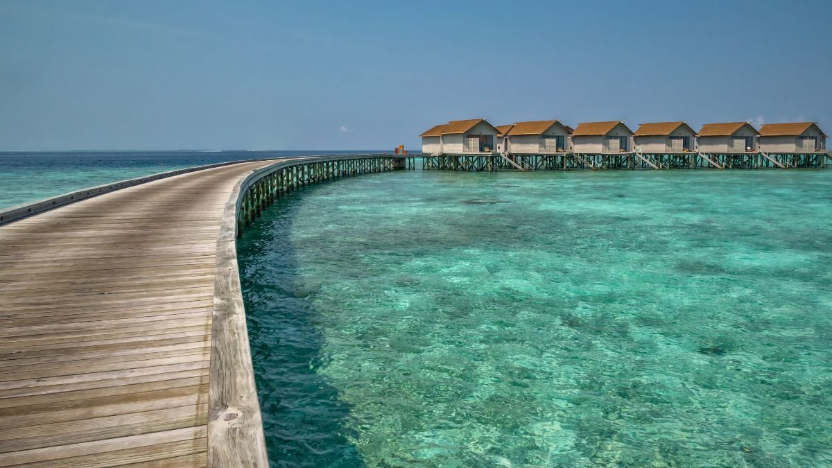 Is Scuba Diving in Maldives Worth It? Diver's Complete Guide » Costa Rica Divers Traditional overwater bungalows in the Maldives photographed at sunset, with calm turquoise lagoon water below.