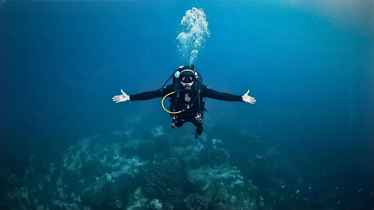Professional diver demonstrating perfect neutral buoyancy hovering motionless in horizontal position mid-water in Costa Rica showing advanced buoyancy control technique