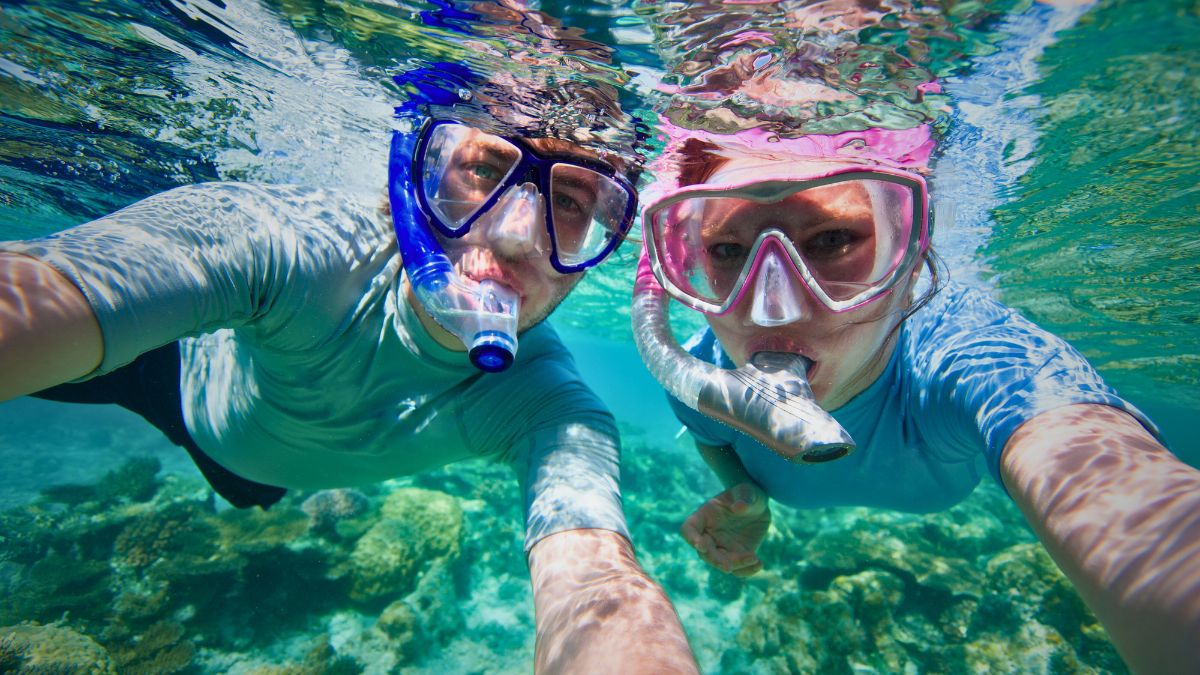 Happy beginner snorkeler floating on surface with mask and snorkel viewing colorful tropical fish in shallow clear Costa Rica waters showing easy accessible activity