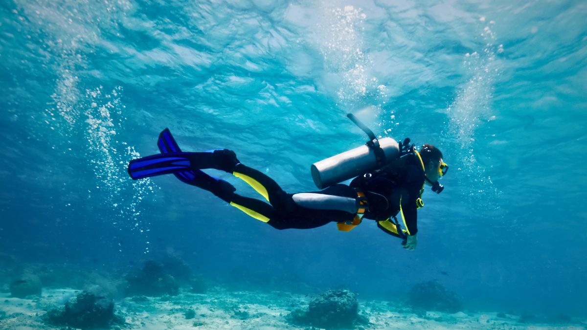 Dive instructor demonstrating scuba equipment to group of students on boat in Costa Rica during comprehensive diving education course