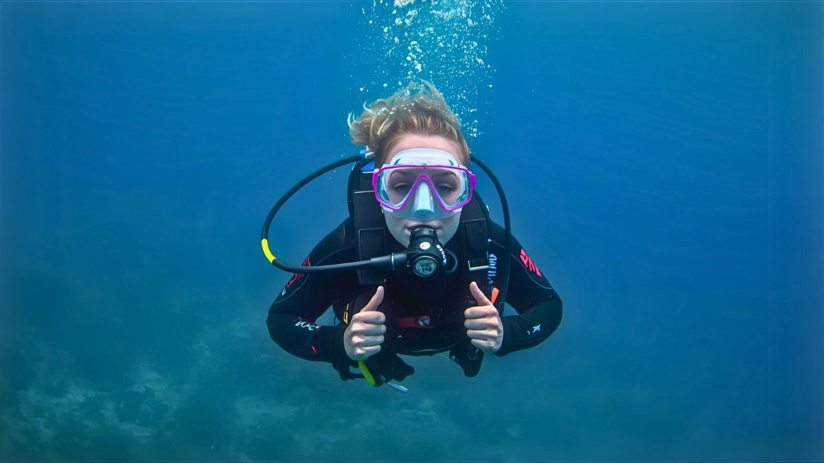 Professional diver demonstrating perfect streamlined horizontal position and relaxed posture for efficient air consumption underwater in Costa Rica