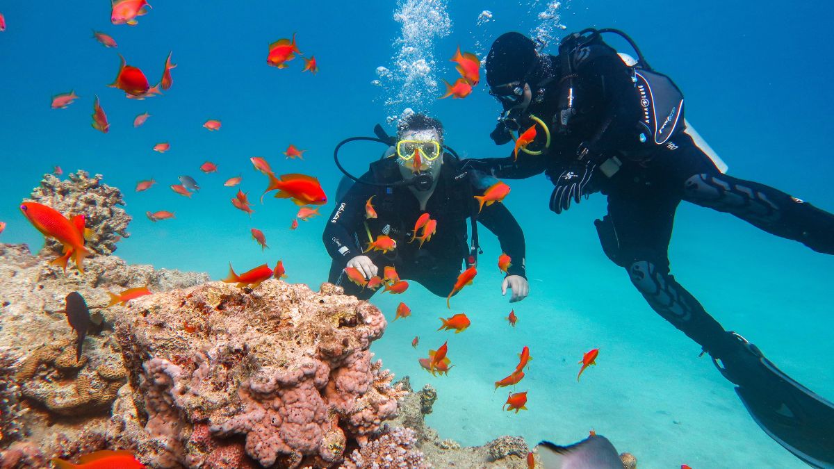 Beginner student smiling confidently while practicing scuba skills in pool with encouraging instructor giving thumbs up in Costa Rica showing easy learning process