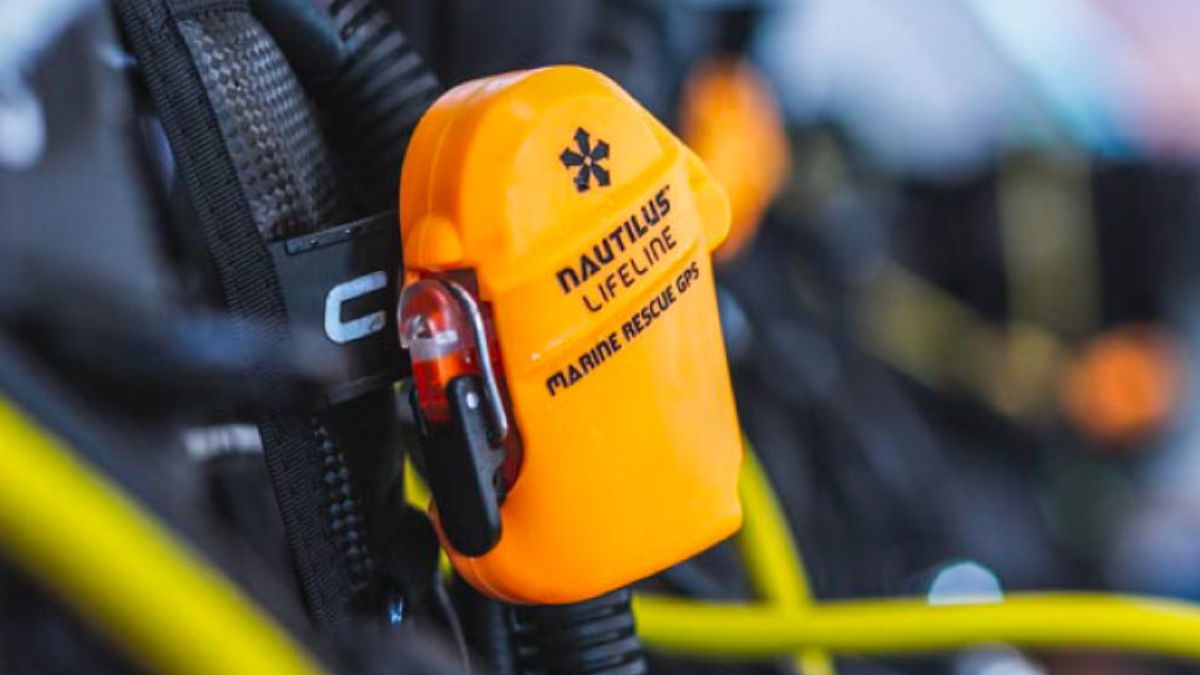 Distressed scuba diver at surface using yellow Nautilus LifeLine GPS device to call for help from distant dive boat during emergency situation