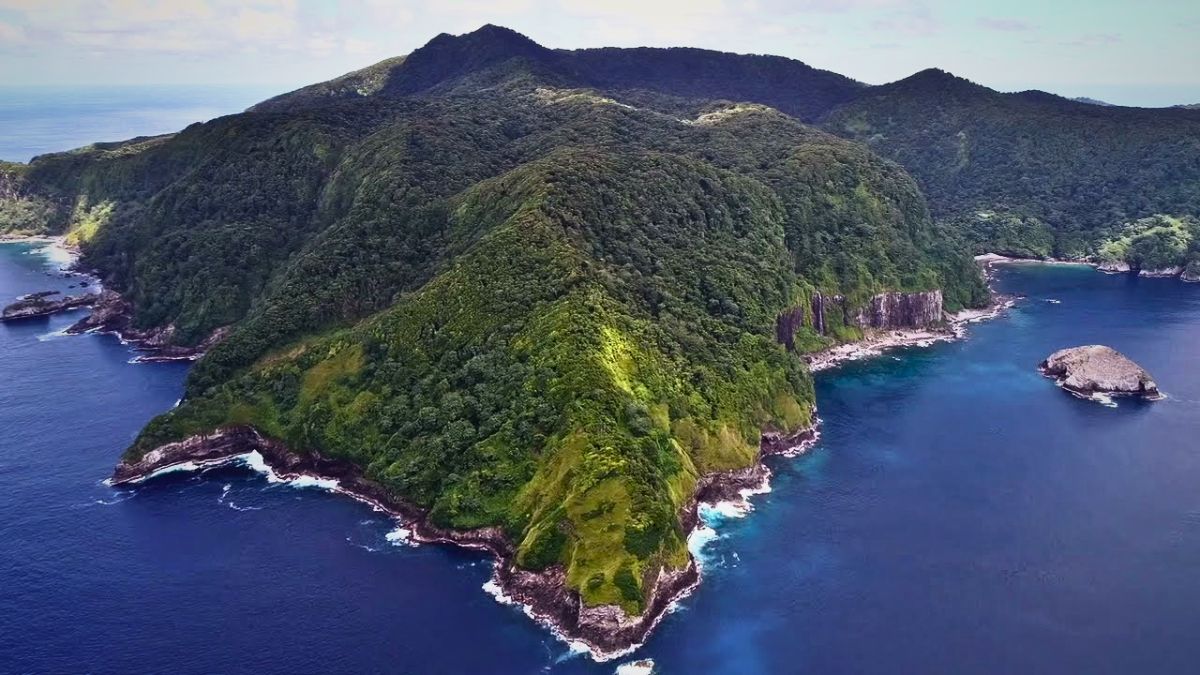 Aerial view of remote Isla del Coco volcanic island surrounded by deep blue Pacific Ocean in Costa Rica showing lush jungle and dramatic coastline
