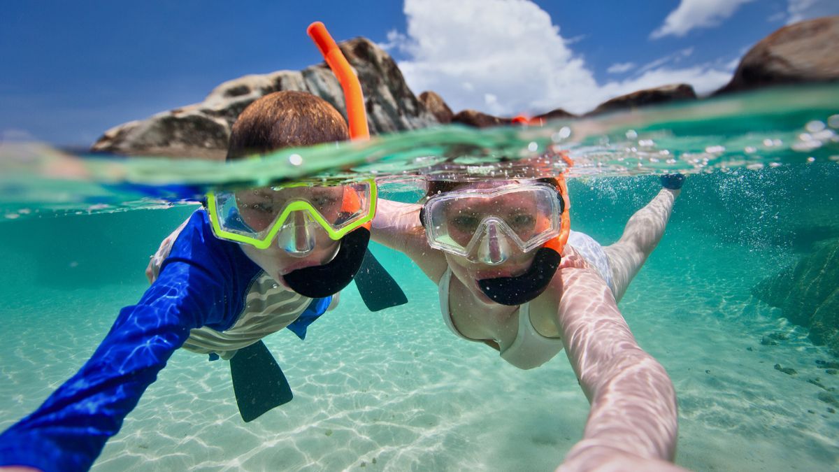 Snorkeling For Beginners: Your Complete Guide to Getting Started » Costa Rica Divers Snorkeler floating on surface viewing colorful coral reef in shallow waters of Costa Rica