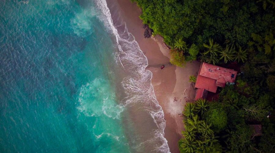 Scuba diver exploring pristine coral reef with tropical marine life and manta rays at Isla del Caño Costa Rica in crystal clear blue water