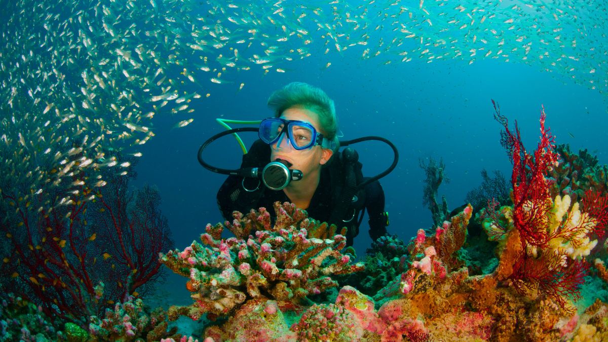 First-time scuba diver with professional instructor underwater in shallow clear Costa Rican waters during beginner-friendly discover scuba diving experience
